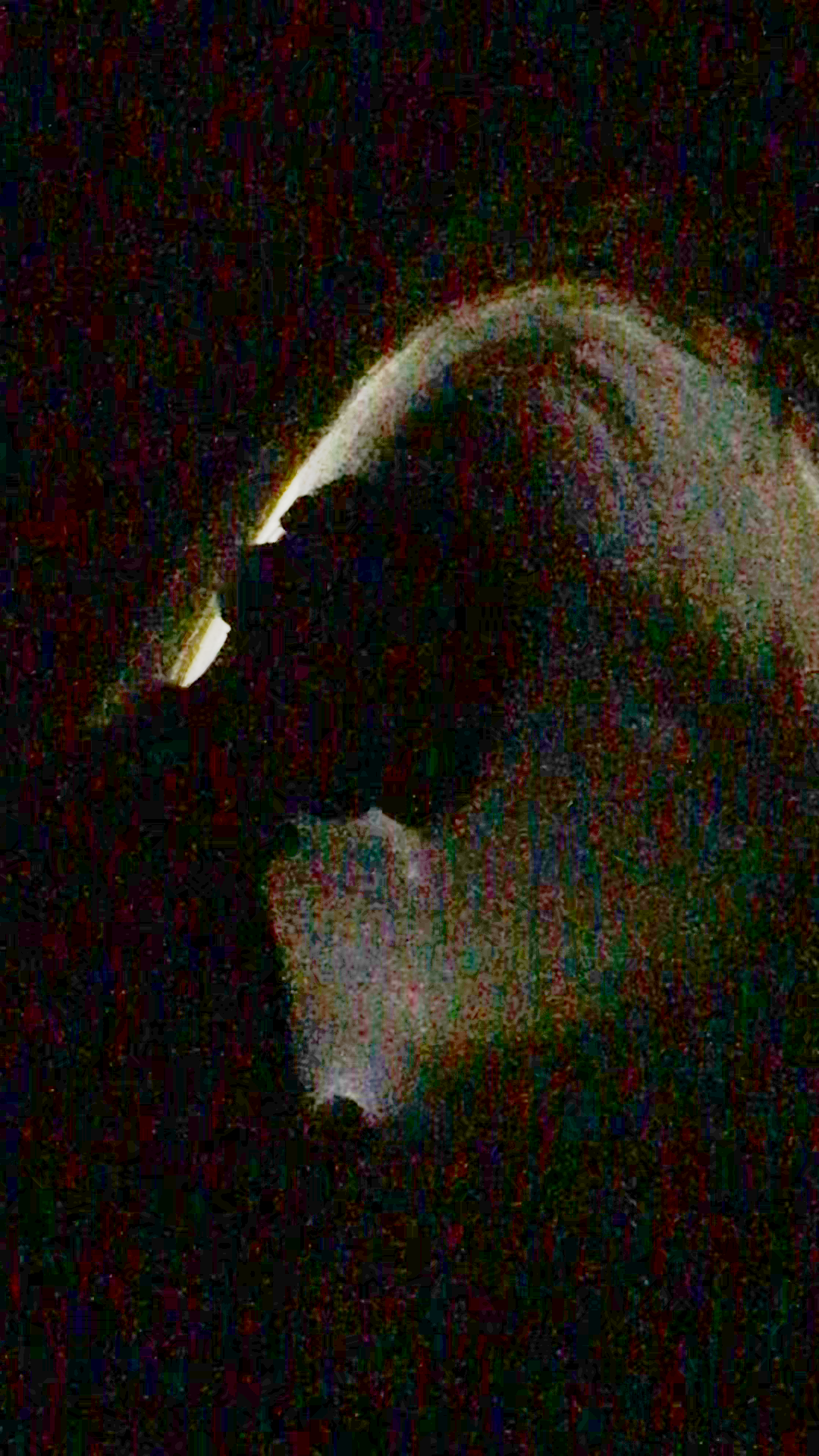 A low-fi photo of a person silhouette in a tunnel holding a light